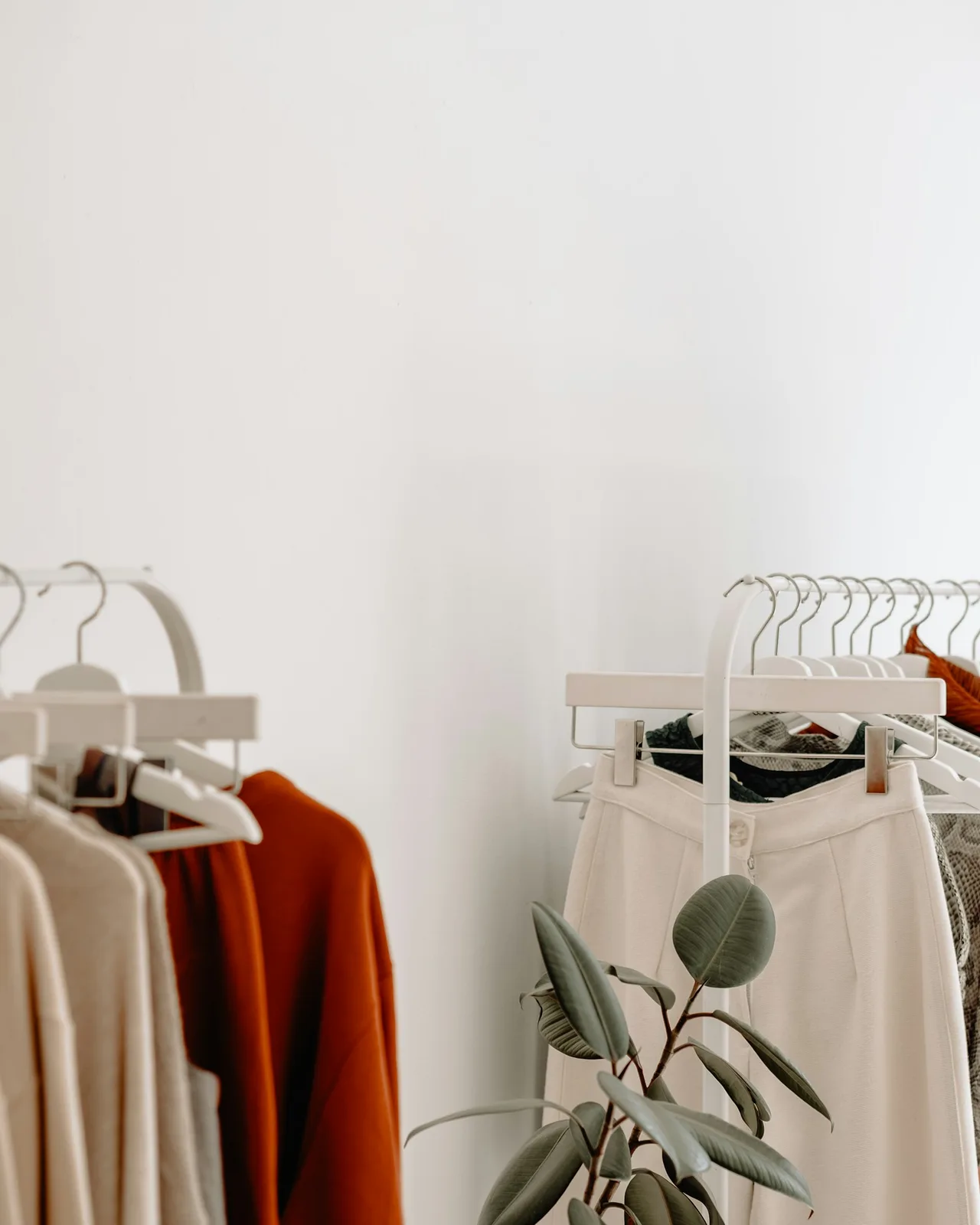 Butikte askıda nötr renkli kıyafetler